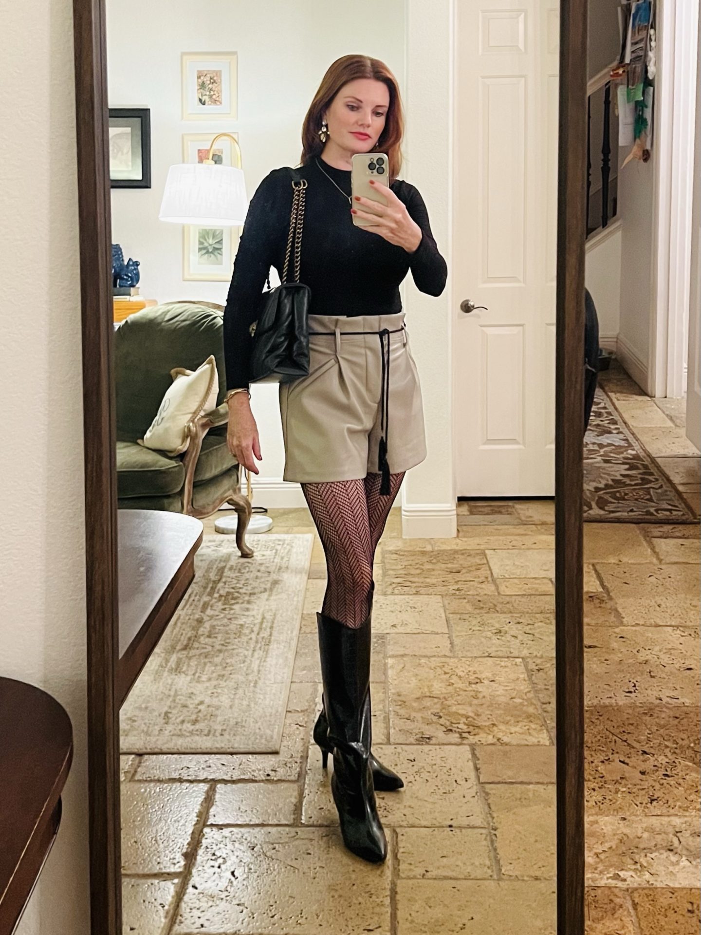 simple date night look featuring faux leather shorts and patterned tights with faux leather croc boots.